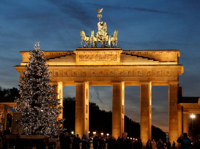An illuminated Christmas tree is pictured in front of the Brandenburg Gate in Berlin
