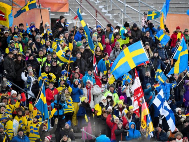 Supporters wave flags during the women's 7,5km sprint race at the Biathlon World Cup in Ostersund